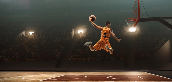 Jogador de basquete com uniforme amarelo a afundar bola no cesto